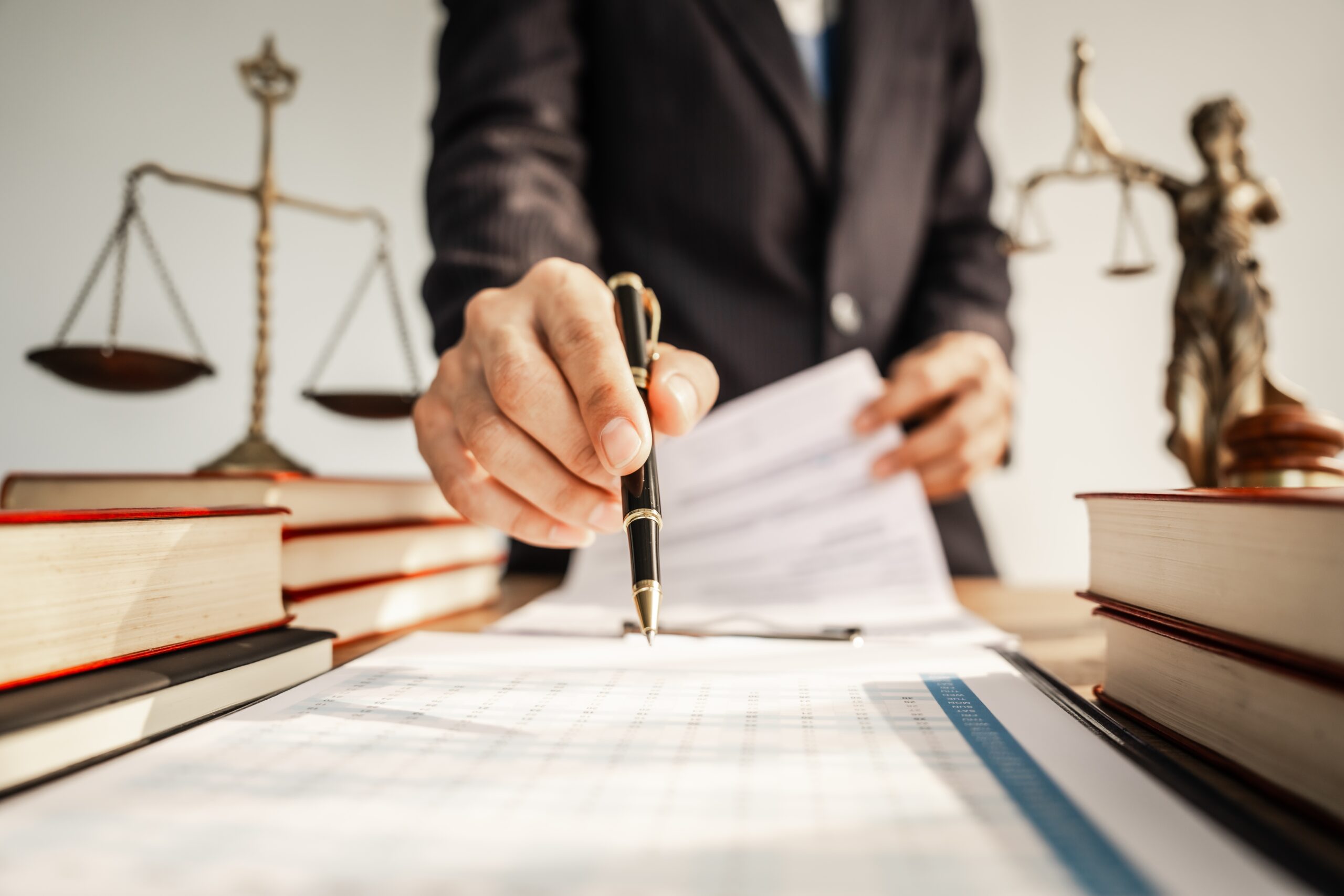 Attorney reviewing and signing legal documents with focus on ethical and caring representation